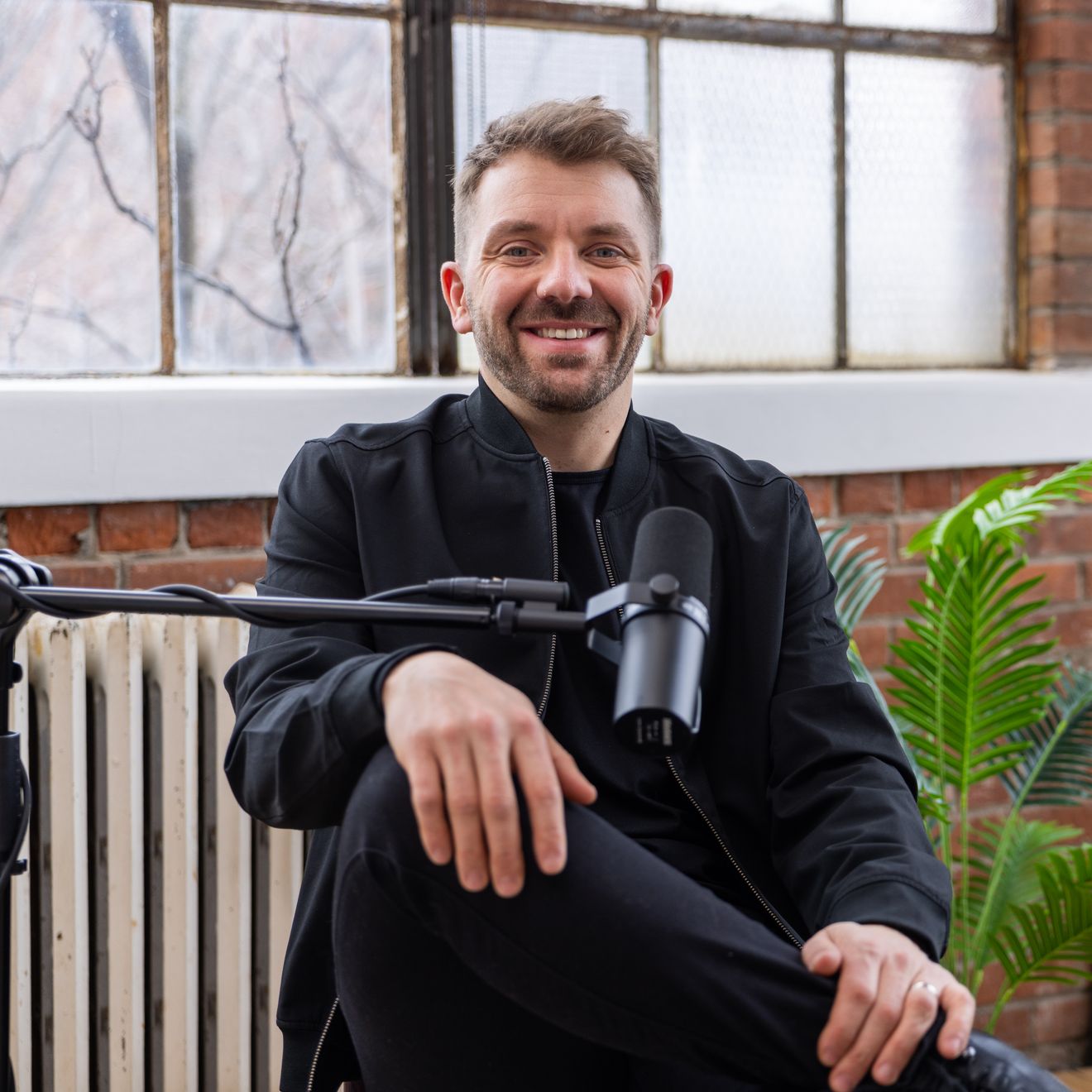 Guest smiling at a microphone in the brick loft