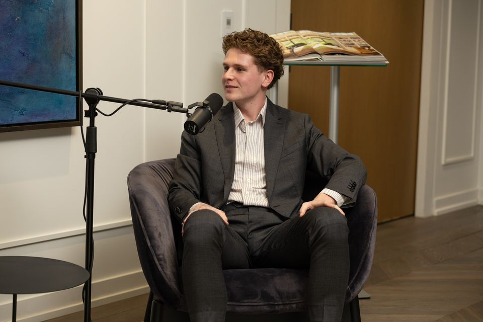 Guest in an armchair beside a large abstract painting